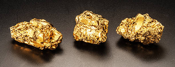 Glittering gold nuggets on black background