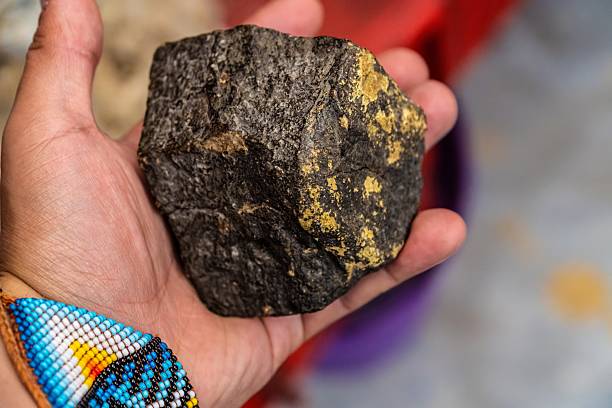 Hand holding raw gold ore mineral stone specimen